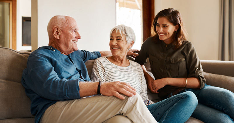A woman takes on caregiving as an only child with a smile while spending quality time with her aging parents.